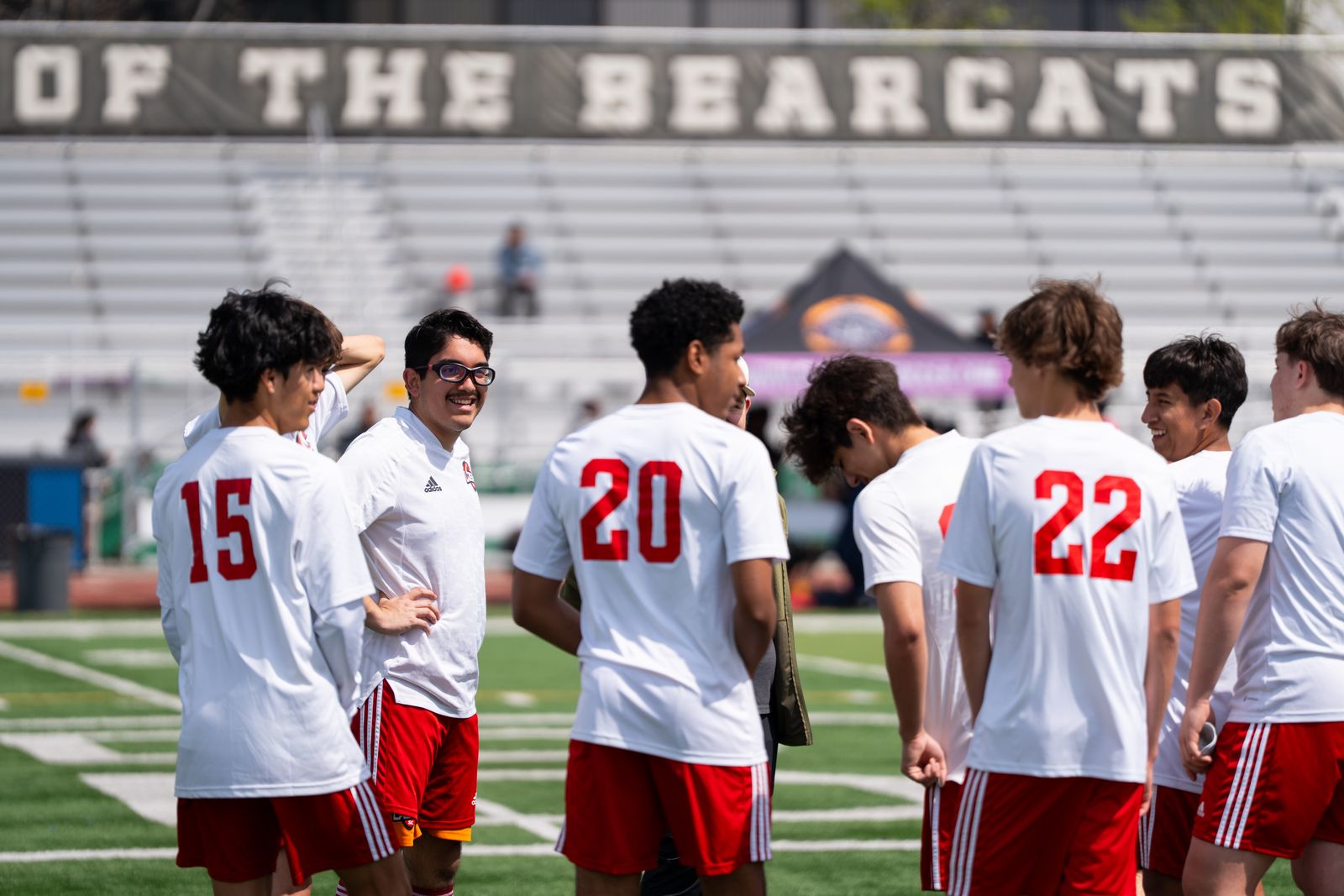 Soccer players in red and white jerseys gathered on the field